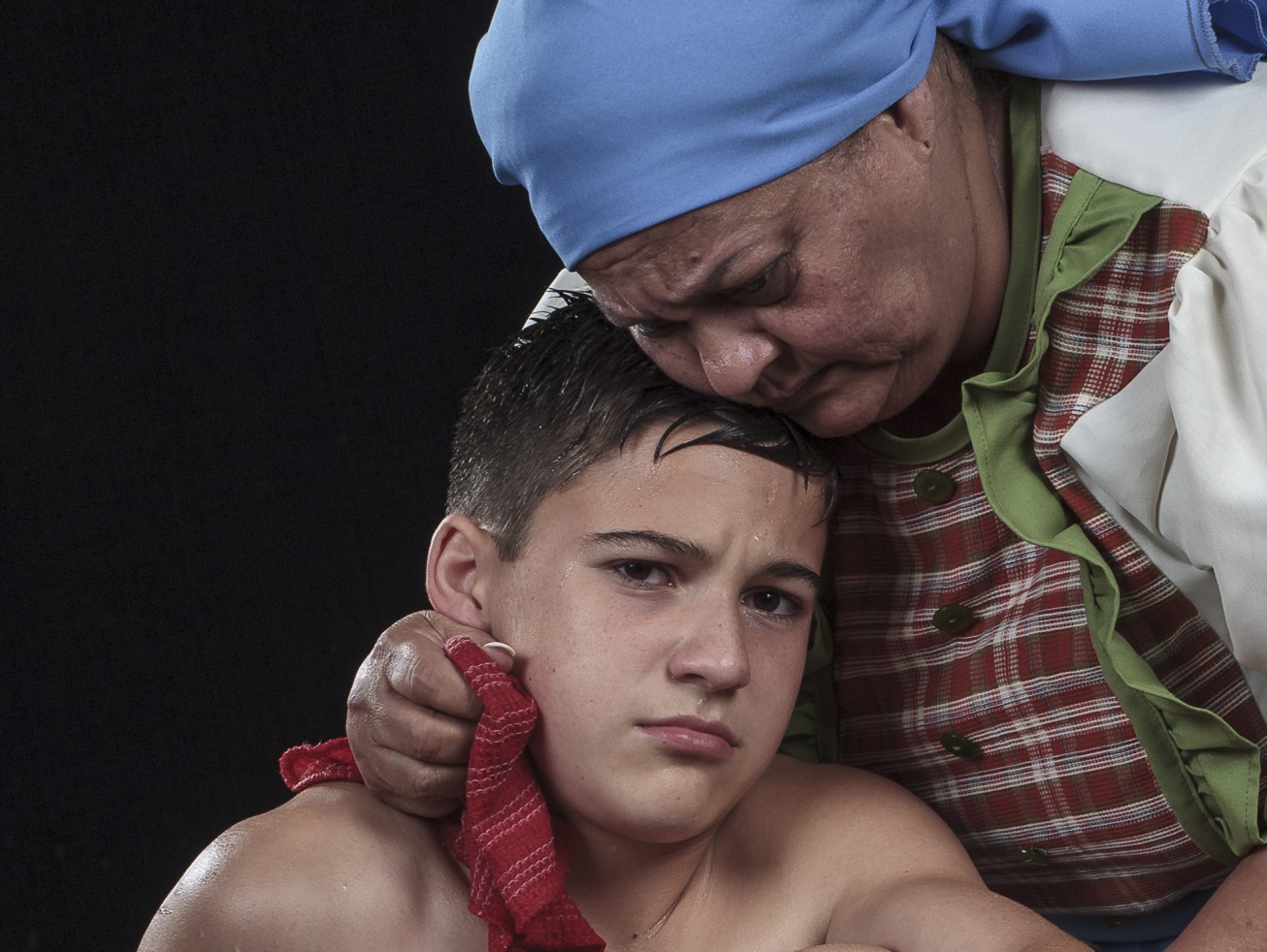Fiela droog 'n seun se nek af met 'n rooi doek en hou hom teen haar vas.